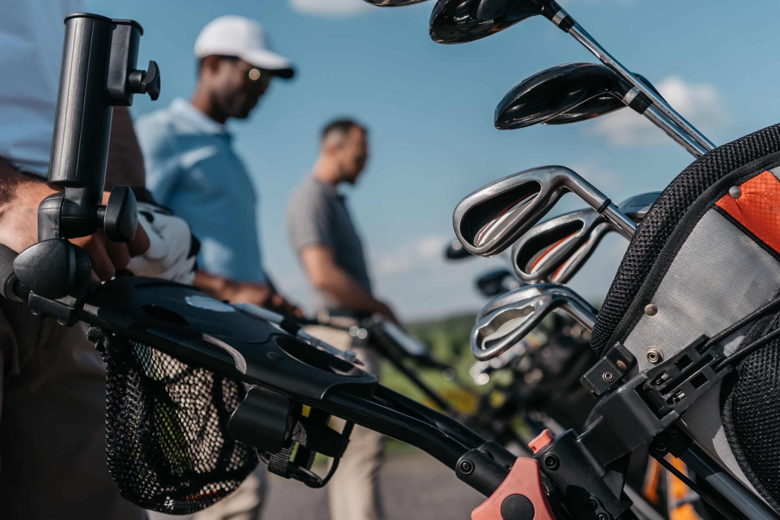 sportsmen going to the golf course, selective focus on bag with clubs at foreground
