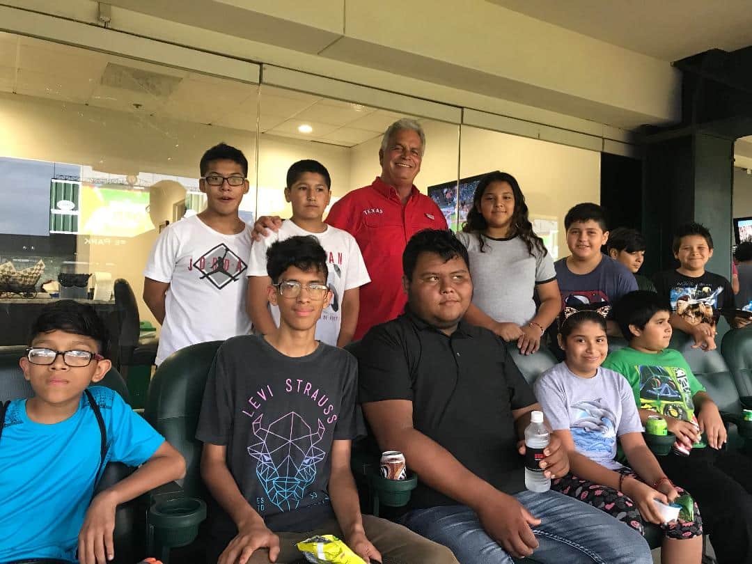 Men Serving God volunteer with a group of kids enjoying a game day experience at a local sports stadium